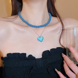Double-layer necklace featuring a blue heart pendant and Morandi blue beads on a model