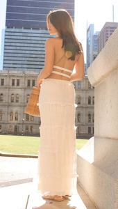 Outdoor street shot of women's white sleeveless top and tiered maxi skirt set for summer
