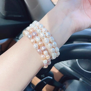 Close-up of natural white, pink and purple freshwater pearls bracelet worn by a model