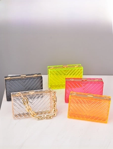 Detail of acrylic crossbody bags with V-shaped texture and gold metal chain straps