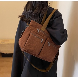 Detailed back view of a brown corduroy tote bag with multiple pockets worn by a model