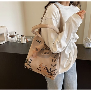 Close-up of cute cartoon animal prints on beige canvas tote bag with soft fabric texture