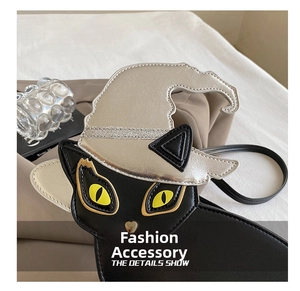 Detail shot of a black leather cat-shaped bag featuring a silver wizard hat design
