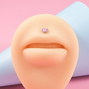 Detail of pink heart-shaped opal lip stud on a silicone lip model for piercing display
