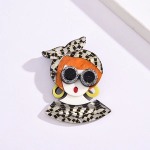 Close-up of pop art acetate brooch featuring a girl with headscarf and sunglasses