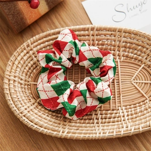 Christmas hair scrunchie with red and green diamond pattern in a woven basket display
