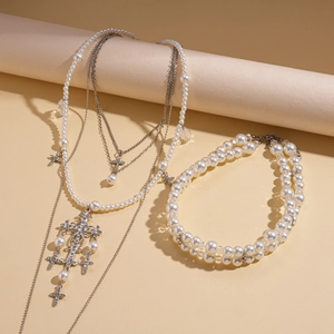 Detailed macro view of two-layer pearl necklace with sparkling rhinestone cross pendants