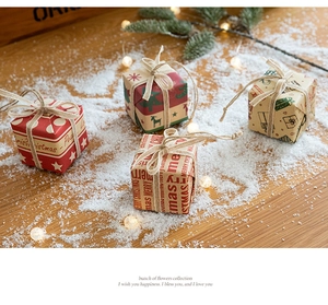 Detailed view of assorted Christmas mini gift boxes with twine bows on snowy wood surface