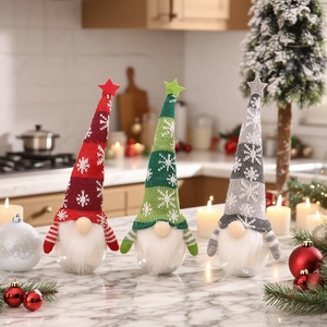 Three Christmas gnomes with knitted hats and transparent bases on a marble table