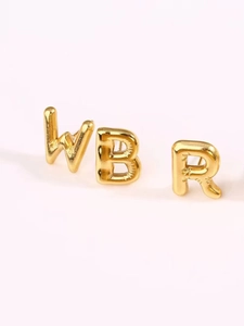 Detailed view of polished 18k gold plated balloon style alphabet stud earrings W B R