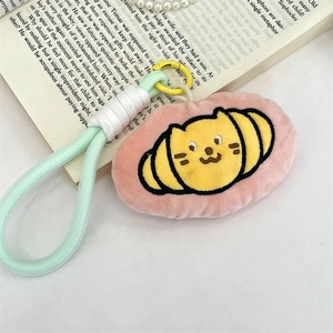 Detail of plush cat croissant keychain with mint green strap and yellow plastic clip