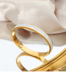 Detailed close-up of a gold-plated stainless steel hinged bangle with micro-pave crystals