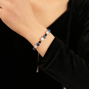 Détail du bracelet réglable en métal avec pierres précieuses rondes bleues, blanches et noires