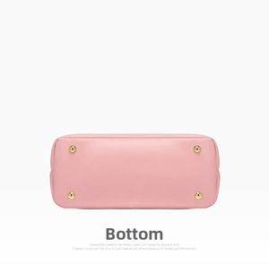 Detail view of the pink grained leather handbag base with four gold protective metal feet