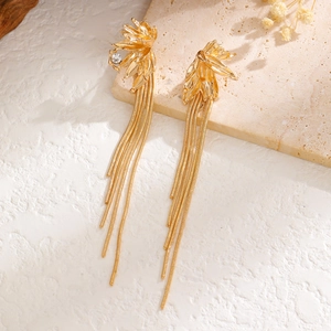 Elegant gold leaf tassel earrings with sparkling zircon on a textured stone surface
