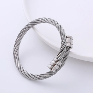 Close-up of a double-layered silver steel cable bangle with polished cylindrical ends