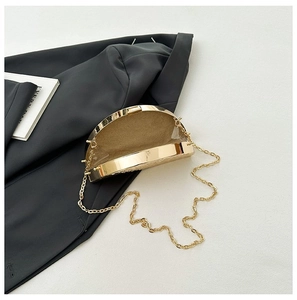 Detail of golden metallic evening clutch showing tan flocking lining and gold chain strap