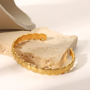 Détail du bracelet en acier inoxydable plaqué or 18K avec texture coquillage
