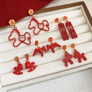 Detailed set of festive red and gold New Year earrings with horse and Fu motifs