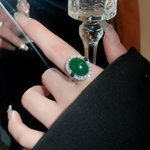 Détail d'une bague ovale en agate vert émeraude avec halo de zircon porté