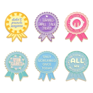 Set of 6 colorful enamel medal brooches with motivational English text on white background