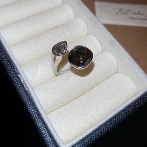 Detailed close-up of a silver open ring with teardrop and cushion-cut brown stones