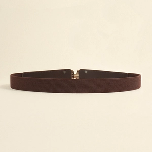 Detail of dark brown elastic waist belt featuring a refined gold interlocking metal buckle