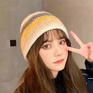 Close-up of tie-dye knitted beanie showing colorful stripe texture and warm casual design