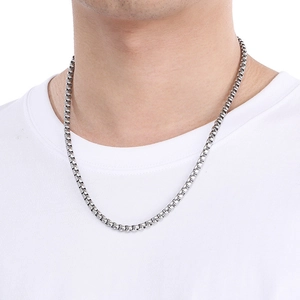 Detail shot of a silver stainless steel box chain necklace worn by a male model