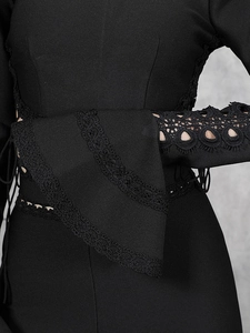 Détail des manches évasées en dentelle et du tissu élastique noir sur un ensemble ajusté