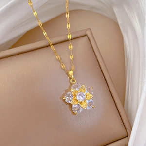 Macro shot of gold floral pendant with zircon inlay on a soft silk and matte background