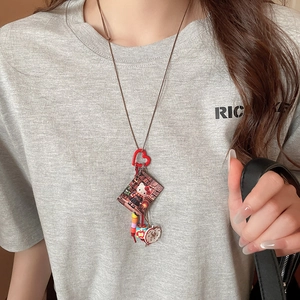 Close-up of resin square pendant with Hello Kitty motif and cute apple charm detail