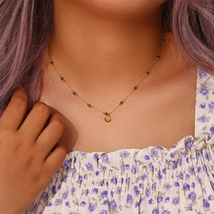 Detail of shell pendant necklace with green beads worn on neck for fashion