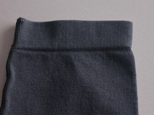 Gros plan sur le tissu noir sans couture du body avec poignets élastiques côtelés