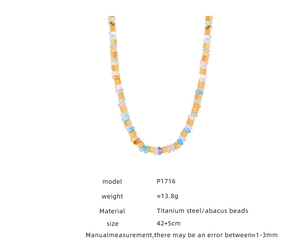 Détail des perles colorées et des entretoises en acier titane doré sur le collier