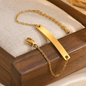 Detail of gold-plated stainless steel bar bracelet displayed on a premium jewelry box