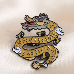 Close-up of golden enamel dragon brooch featuring intricate white clouds and brown mane