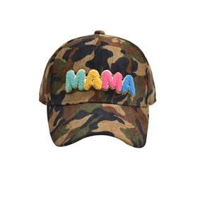 Close-up of MAMA chenille patches with gold glitter trim on camouflage corduroy cap
