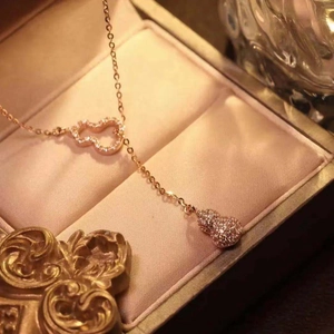 Close-up of rose gold gourd and heart pendant necklace in a luxury jewelry box