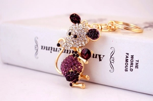 Close-up of golden mouse keychain featuring purple rhinestones and crystal details