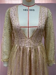 Nahaufnahme vom rosa Glitzerkleid mit langen Ärmeln und feiner Goldstickerei-Verzierung