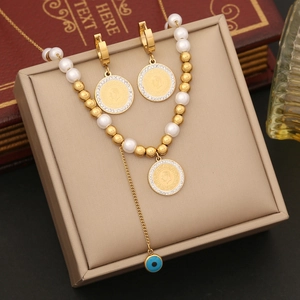 Golden coin portrait necklace with pearls and matching earrings set on vintage display