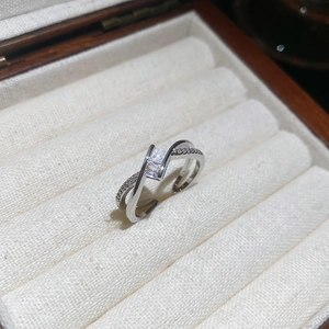 Macro detail of a silver crossover ring with white zircon stones and an open adjustable band