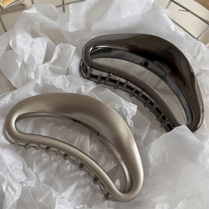 Matte and glossy hollow moon hair claws in champagne gold and deep grey metal