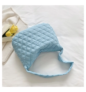 Detailed top view of light blue quilted nylon shoulder bag with soft cloud texture