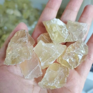 Close-up of hand holding natural raw citrine quartz stones for home aromatherapy decor