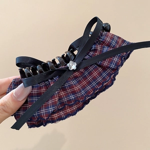 Detailed close-up of British style plaid bow hair claw clip with crystal flower accent