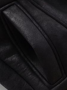 Vue détaillée montrant les coutures fines et la texture du cuir premium du gilet noir