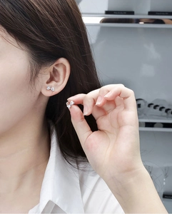 Detailed close-up of butterfly zircon earrings in silver finish on a female model