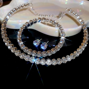 Macro view of silver luxury jewelry set with shimmering round crystals on black surface